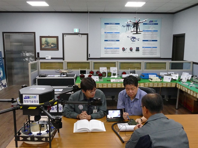 오병후(뒷줄 오른쪽) 창원기술정공 대표가 경남 창원시 회사 사무실에서 지뢰탐지 드론의 원리를 설명하는 모습. 창원기술정공 제공